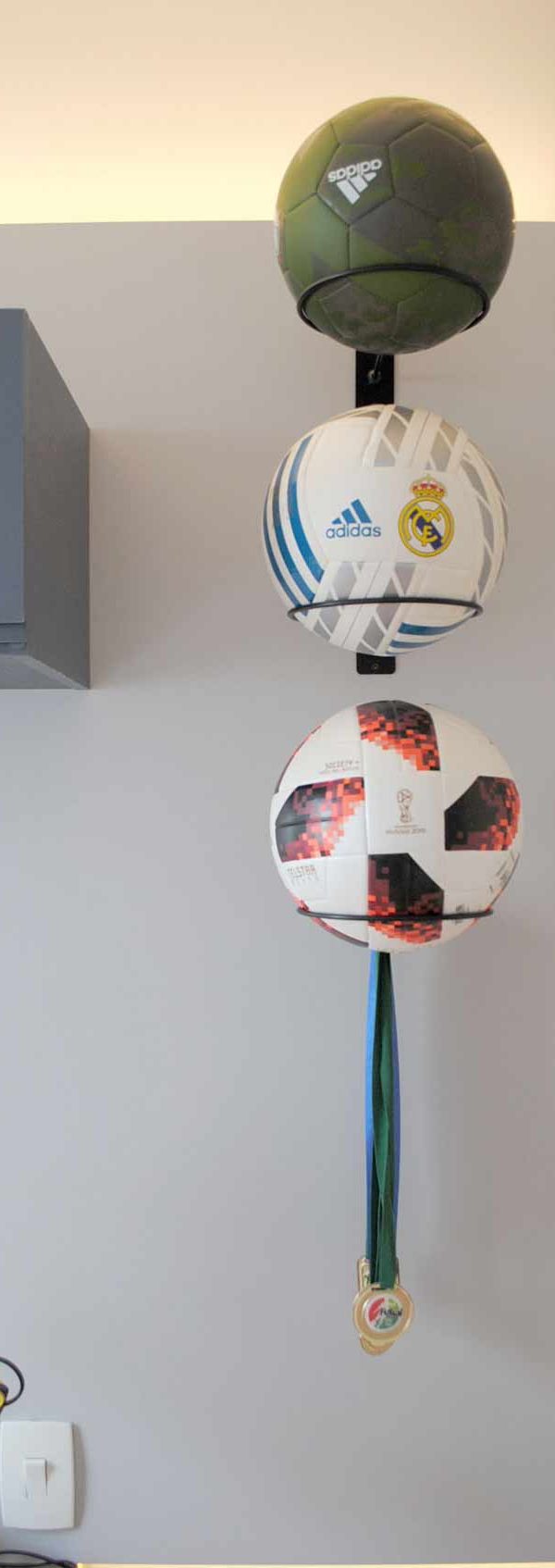 Ganchos metálicos exibem bolas e medalhas